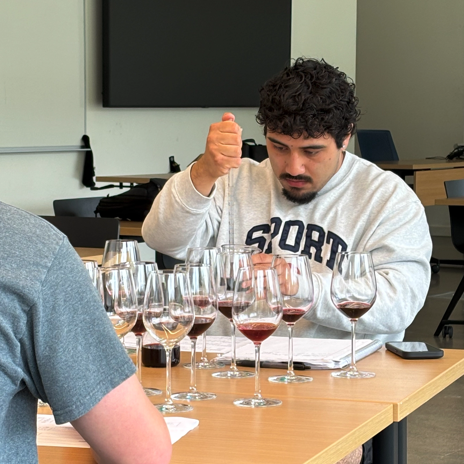 A student in a wine class working with wine.